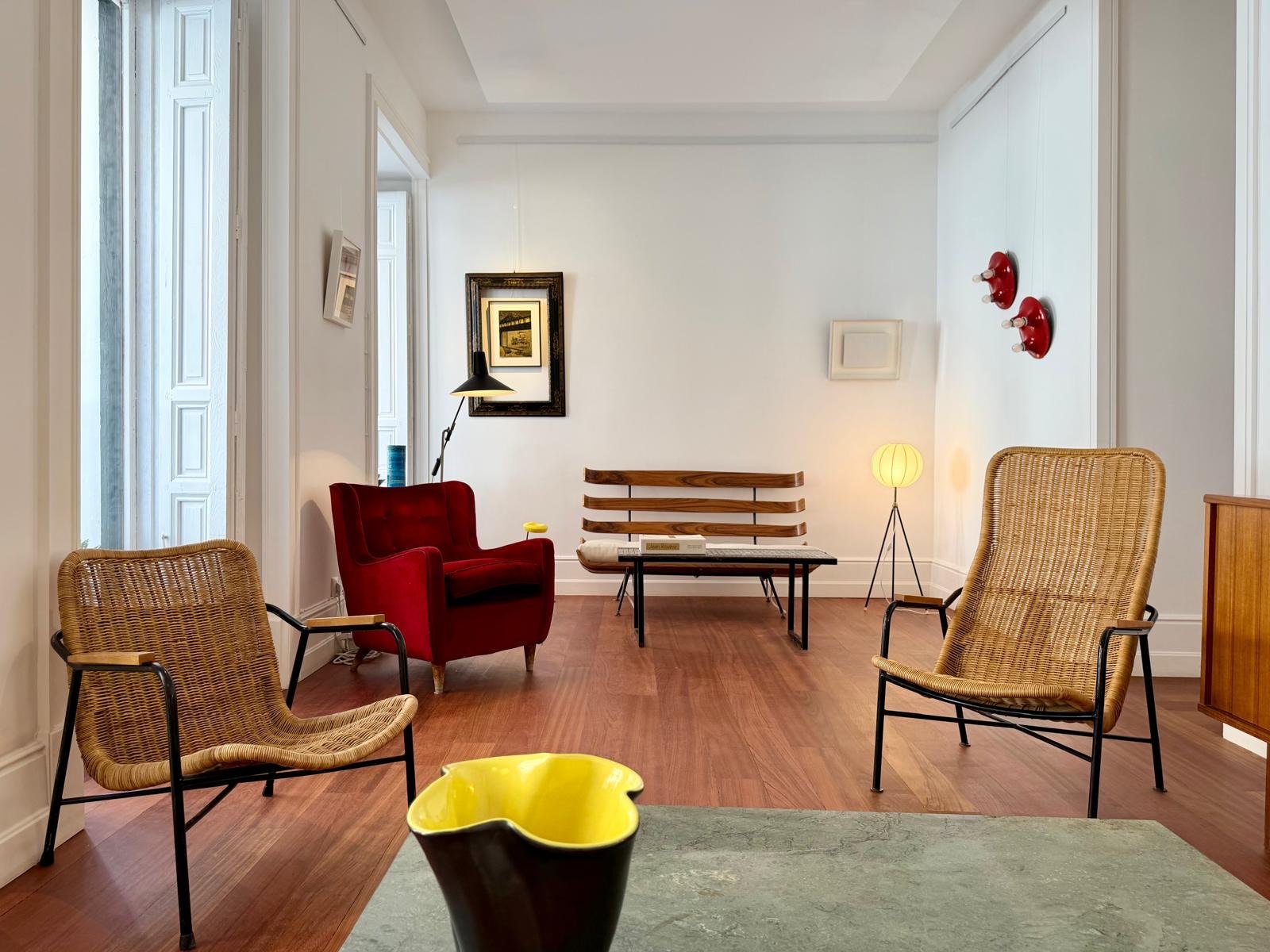 Salón con butacas de mimbre y sillón rojo